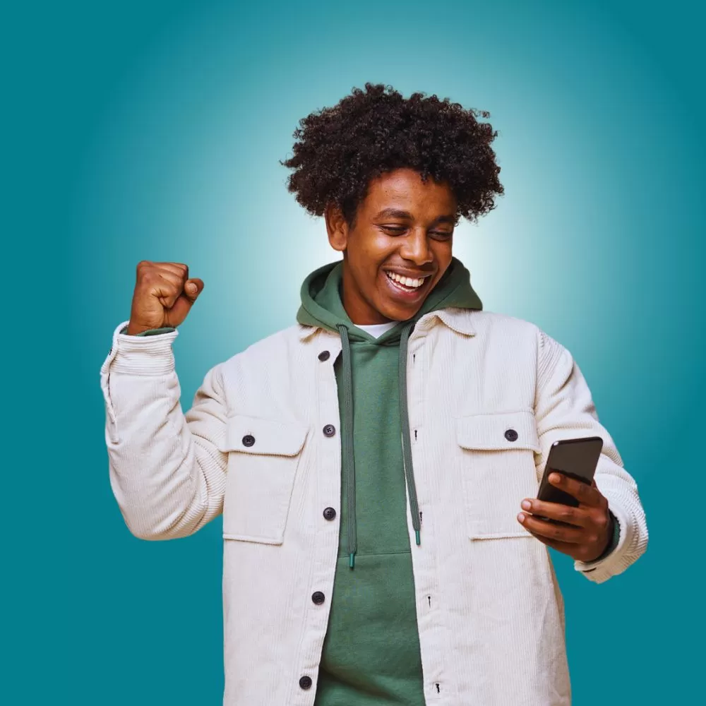 teen boy smiling at phone, excited